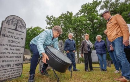 Maartje Luijt plaatst de graftrommel van de familie Zwart-Bosch terug op de begraafplaats Appelscha. (foto © Rens Hooyenga)